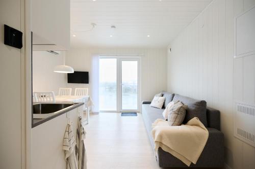 a living room with a couch and a kitchen at Haludden in Stora Dyrön