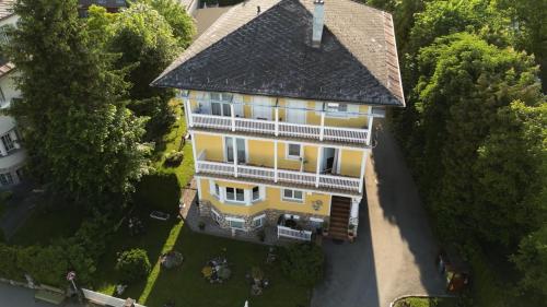 an overhead view of a yellow house with a black roof at Gästehaus Gertrude in Velden am Wörthersee