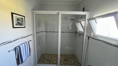 a walk in shower with a glass door in a bathroom at Estadia alegre ao som do mar in Maputo