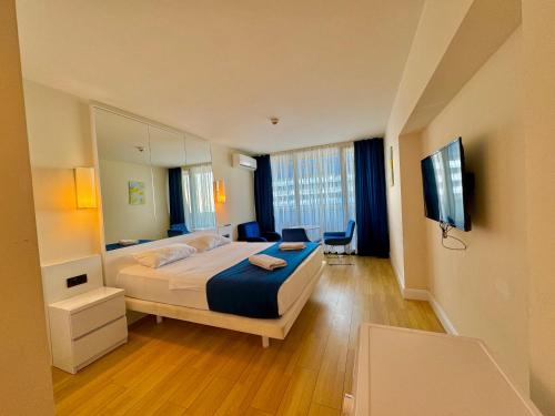 バトゥミにあるLuxsor Rooms In Orbi Cityのベッドとテレビが備わるホテルルームです。