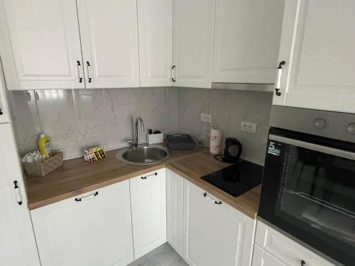 a kitchen with white cabinets and a sink at Motel restoran Sunce in Sremska Kamenica