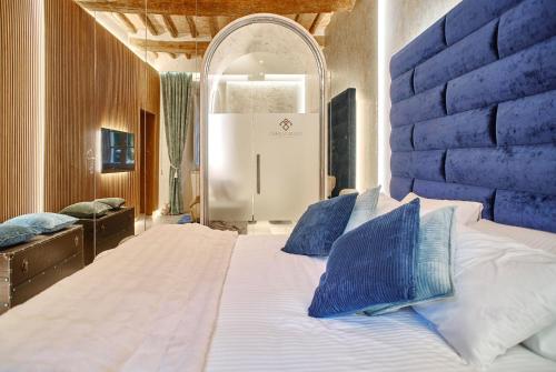 a bedroom with a large white bed with blue pillows at Holiday House CAMILLO BENSO in Perugia