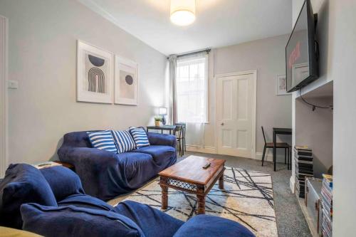 uma sala de estar com dois sofás azuis e uma mesa em Beautiful Apartment with Parking em Hexham
