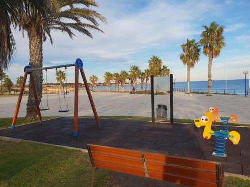 a park with a playground and a swing at Casa Malibu El Rincon Pool view Playa Flamenca in Playa Flamenca