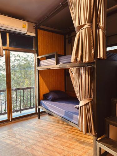 a bedroom with bunk beds and a balcony at Hostel Friends Station & Cafe in Pattaya South