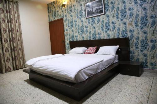 a bed in a bedroom with blue wallpaper at 6 Bedroom private home in Dha Lahore- Phase1 Entire House in Lahore