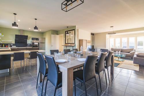 une salle à manger et un salon avec une table et des chaises dans l'établissement Santa Monica, maison spacieuse Reims Cormontreuil, à Cormontreuil