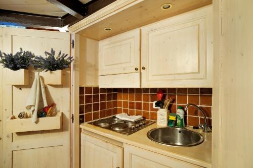 eine Küche mit weißen Schränken und einem Waschbecken in der Unterkunft Appartamento dei Raspi d'uva in Apricale