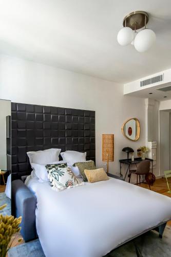 une chambre avec un grand lit avec une tête de lit noire dans l'établissement 302b Beautiful studio refurbished Downtown / Ac, à Nice