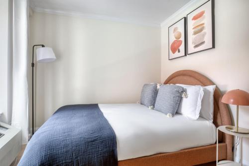 1 dormitorio con 1 cama con almohadas azules y blancas en Nolita 1BR w Elevator Roof Deck nr SoHo NYC-907, en Nueva York