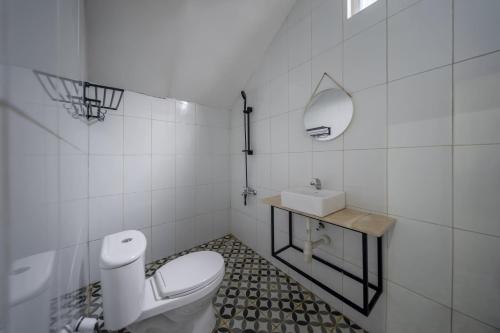 Cove Veranda في جاكرتا: حمام ابيض مع مرحاض ومغسلة
