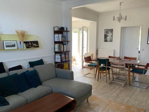 - un salon avec un canapé et une salle à manger dans l'établissement Superbe meulière familiale, à Rosny-sous-Bois