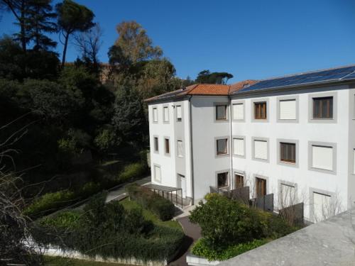 a large white building with trees and bushes at Hotel Il Cantico St. Peter in Rome