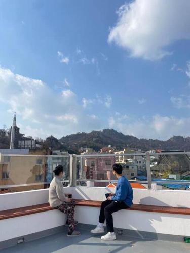 two people sitting on the ledge of a roof at Ogeri76 in Mokpo
