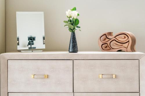 a dresser with a vase of flowers on it at Bramley Brook Cottage 5* Luxury in Whalley