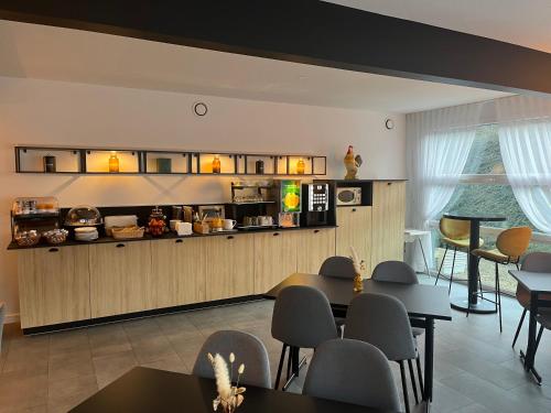 a kitchen with tables and chairs in a room at Hotel Premium in Forbach