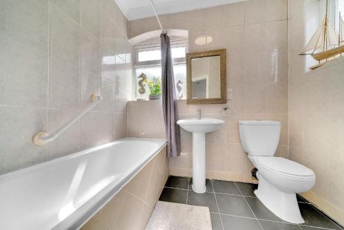 La salle de bains est pourvue d'une baignoire, de toilettes et d'un lavabo. dans l'établissement Large 3 Bedroom House London Denmark Hill, Kings College Hospital Camberwell, à Londres