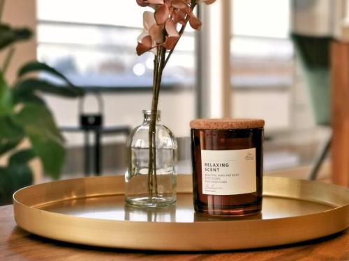 a glass bottle and a vase with a flower in it at Fynbos Deluxe, Penthouse oder Balkon, Parkplatz in Straubing