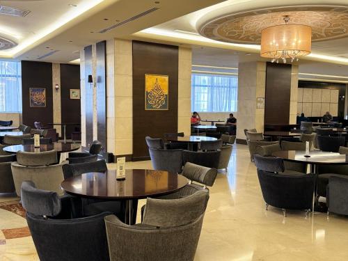 a restaurant with tables and chairs in a building at Al Safwah Hotel Third Tower in Makkah
