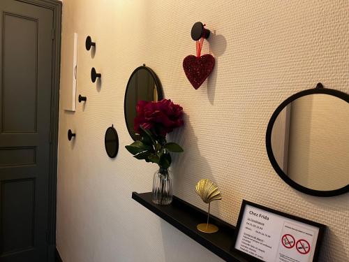 Cette chambre comprend un vase de fleurs et un miroir. dans l'établissement Chez Frida, au Puy-en-Velay