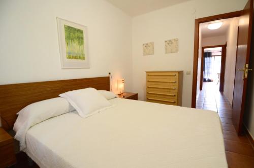1 dormitorio con 1 cama blanca grande y vestidor en Los Pinos, en L'Estartit