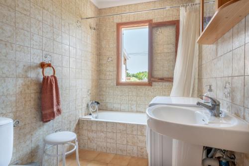 bagno con lavandino, vasca e finestra di Villa Ca na Ventura by Mallorca House Rent a Portocolom