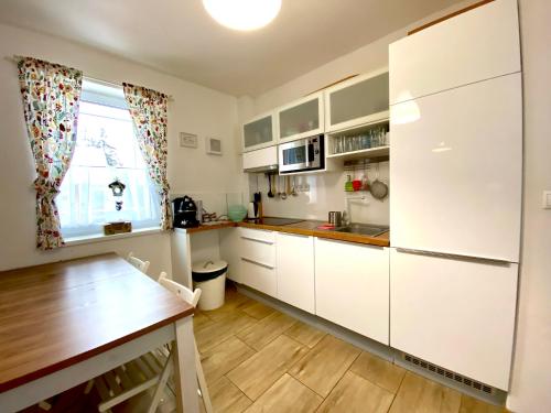 a kitchen with white cabinets and a wooden table at Chalet 3 Domky 182 in Belá