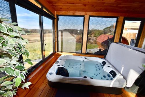 a bath tub in a room with a window at Plaisir d'Eymet du Domaine des Hauts de Rouquette in Eymet