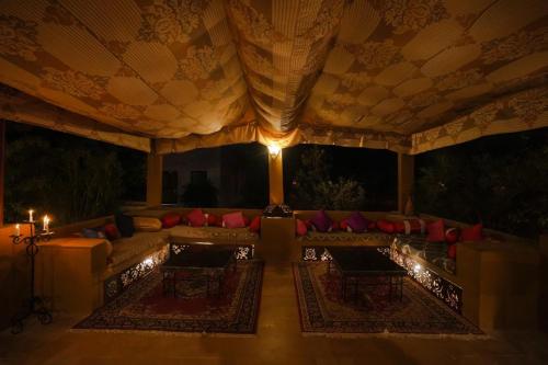 a living room with a couch and red pillows at Prince Desert Camp in Sām