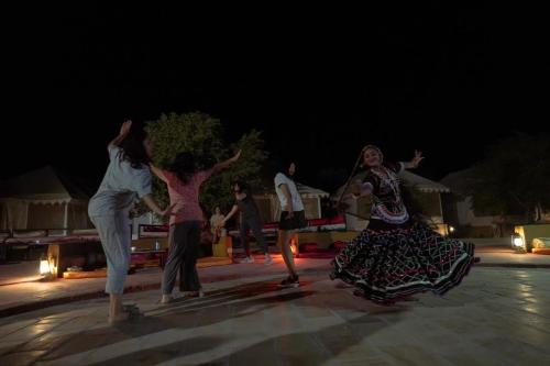 a group of people dancing in the street at night at Prince Desert Camp in Sām