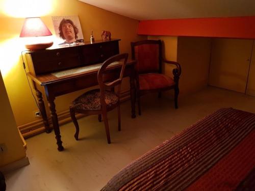 サン・シル・シュル・メールにあるAppartement vue mer à La Madragueのピアノ、椅子、ランプが備わるお部屋