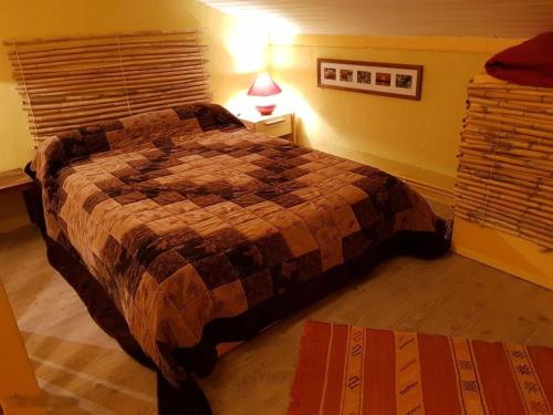 a bedroom with a bed and a lamp on a table at Duplex station alpe du grand serre in La Morte