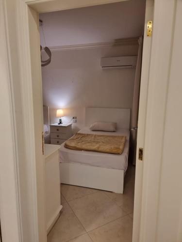 a small white bedroom with a bed and a dresser at شاليه لاجونا باي السخنه Chalet at laguna bay Sokhna in Ain Sokhna