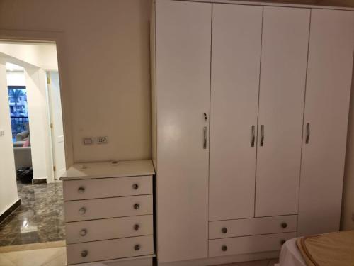 a bedroom with white cabinets and a dresser with a mirror at شاليه لاجونا باي السخنه Chalet at laguna bay Sokhna in Ain Sokhna