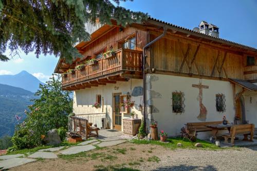 a house with a balcony and a table in front of it at Apt Morgensonne Zunerhof in Campodazzo