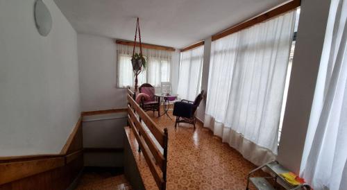 uma sala de estar com uma mesa, cadeiras e janelas em Bosnien Old House em Travnik
