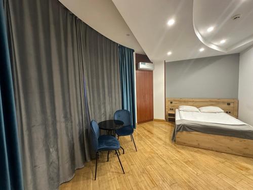 a bedroom with a bed and two chairs and a table at ABC HOTEL in Yerevan