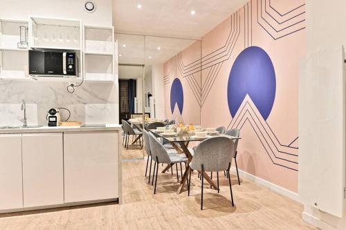 une cuisine et une salle à manger avec une table et des chaises dans l'établissement Appartement central proche Atelier des lumières, à Paris