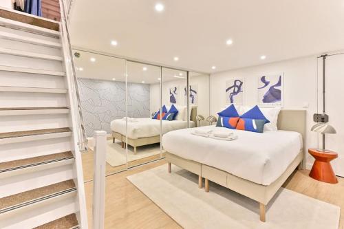 - une chambre avec 2 lits et un escalier dans l'établissement Appartement central proche Atelier des lumières, à Paris