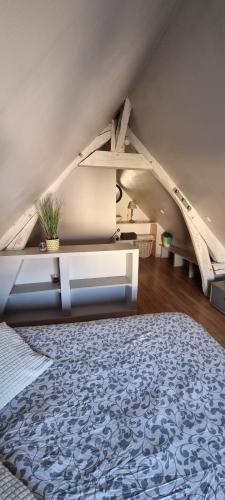 an attic room with a bed and a table at La petite maison en champagne in Payns