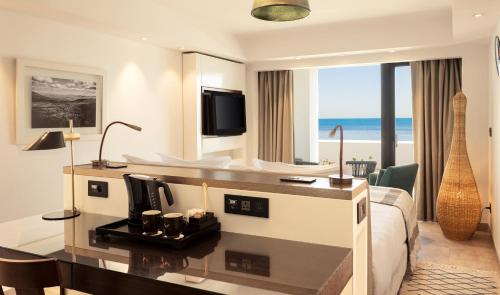 a hotel room with a king bed and a desk at Mövenpick Hotel Gammarth Tunis in Gammarth