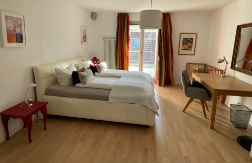 1 dormitorio con cama, mesa y escritorio en Best Location - Luxury Loft Riverview, en Heidelberg