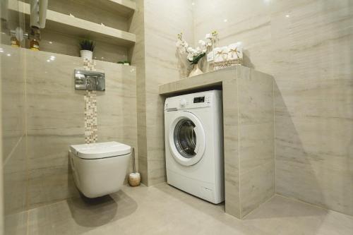 een badkamer met wasmachine en toilet bij Silver Apart Rzeszów in Rzeszów