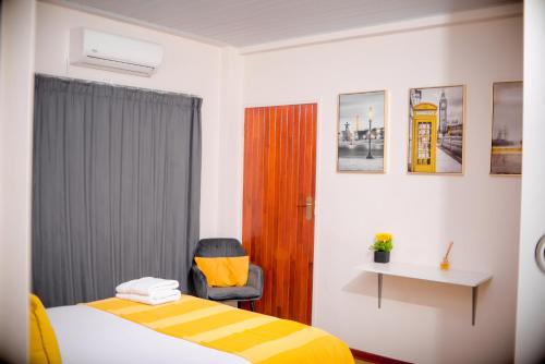 a hotel room with a bed and a chair at 1 Bed Flat Perfect For Couples By Game City Mall in Gaborone