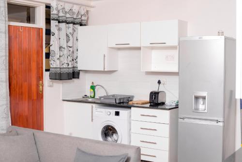 a kitchen with a sink and a washing machine at Entire 1 Bed, 5 mins 2 Game City, free Netflix & showmax in Gaborone