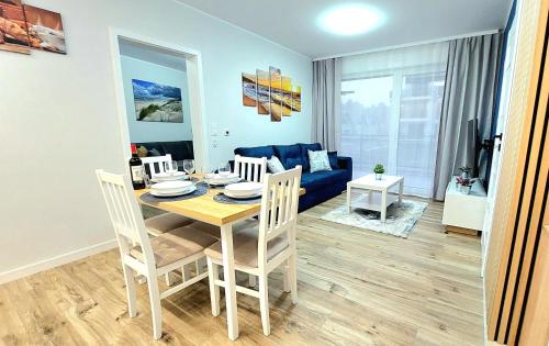 jadalnia ze stołem i niebieską kanapą w obiekcie Apartament Perła Jantaru by TriApart w mieście Jantar