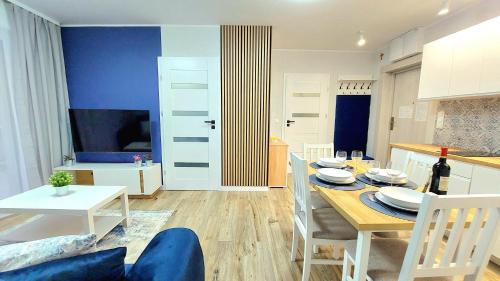 a kitchen and dining room with a table and chairs at Apartament Perła Jantaru by TriApart in Jantar