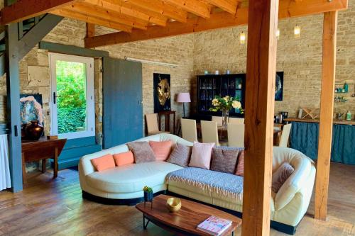 uma sala de estar com um sofá e uma mesa em Les Gîtes de Pronleroy l Gîte Rural Pour Grands Groupes En Picardie em Pronleroy
