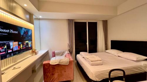 um quarto com uma cama e uma televisão de ecrã plano em West Vista Apartment JKT Modern Design w/55” TV and 40/mbps Wi-fi em Jakarta