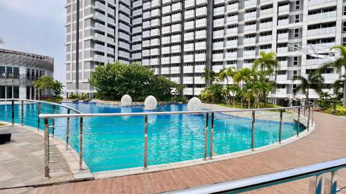 a large swimming pool in front of a tall building at West Vista Apartment JKT Modern Design w/55” TV and 40/mbps Wi-fi in Jakarta